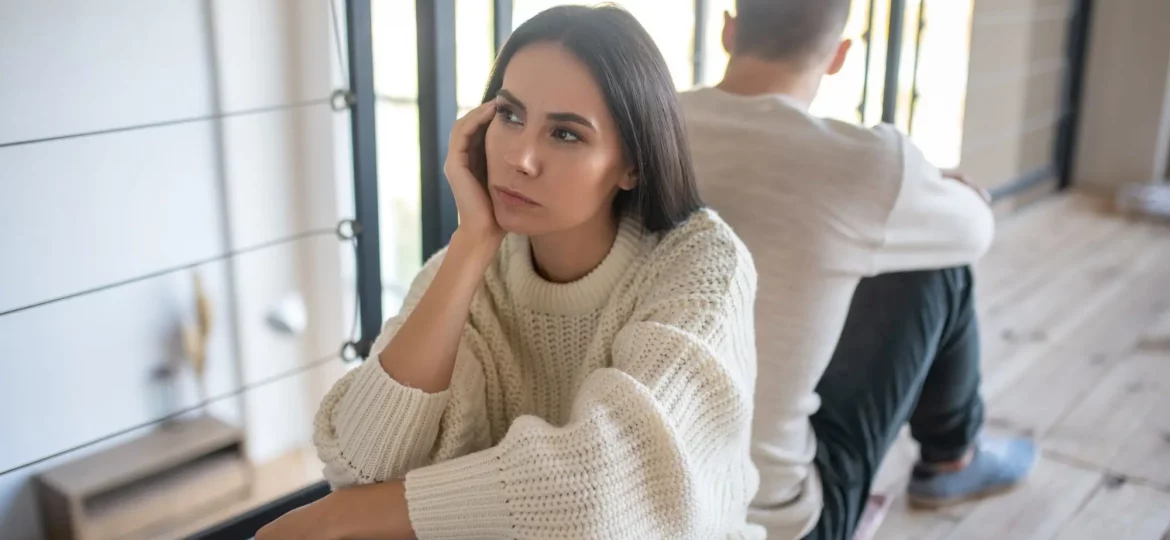 Paar sitzt nach Streit Rücken an Rücken und erlebt emotionales Gefühlschaos in der Beziehung