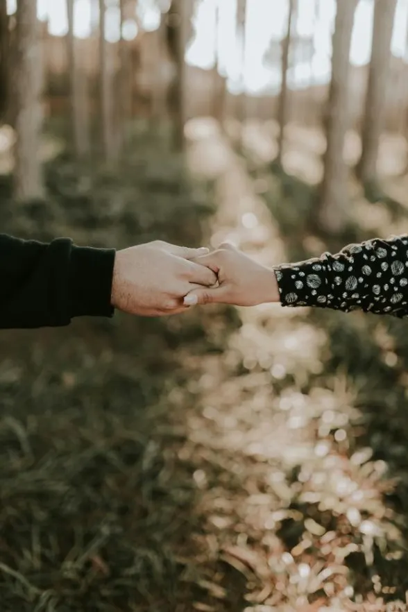 Zwei Menschen halten sich an den Händen als Zeichen von Nähe und Verbindung in der Beziehung