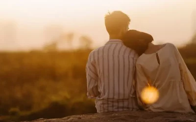 Paar lehnt sich aneinander im Sonnenuntergang – Symbol für Nähe, Verständnis und Versöhnung im Kurs Liebe ohne Kampf